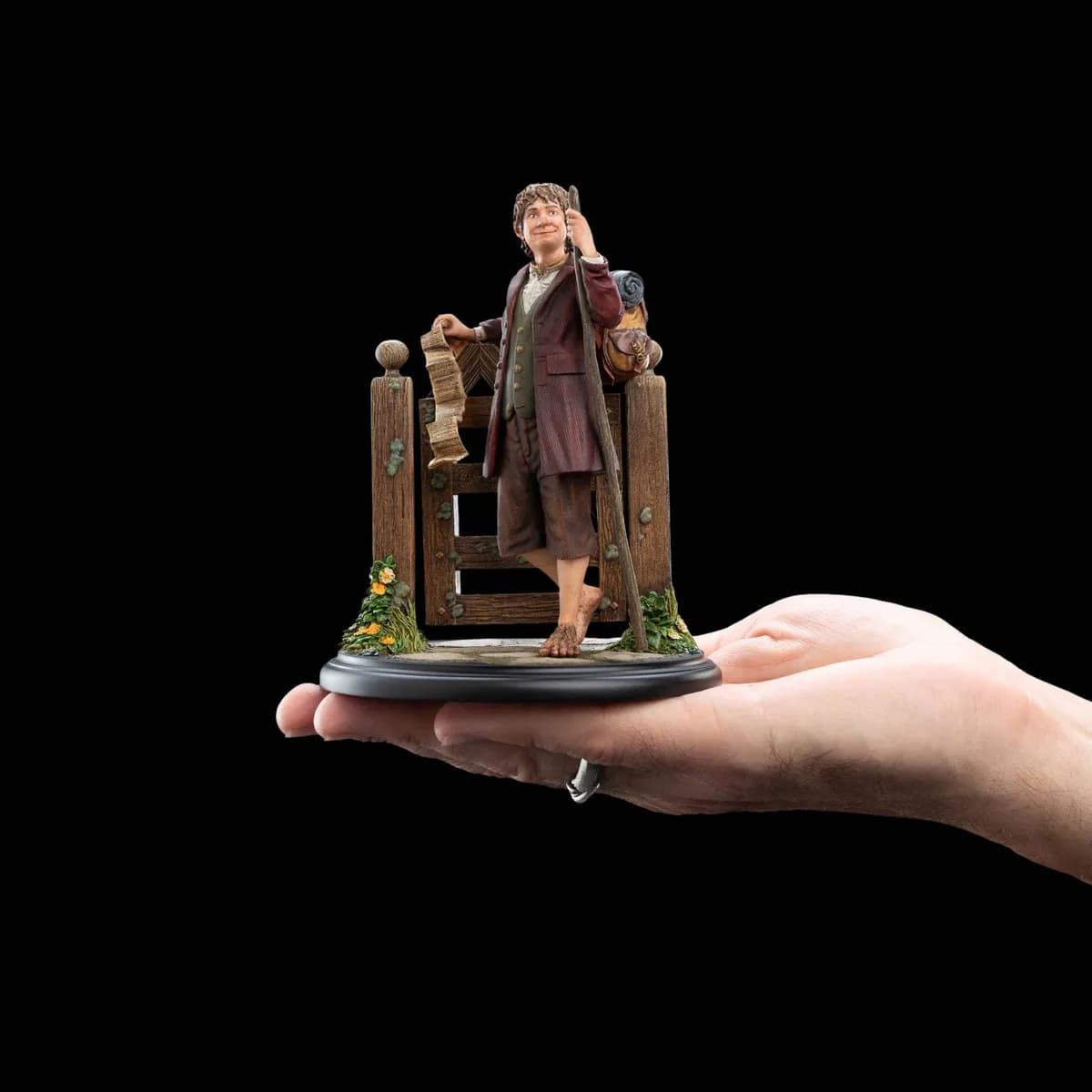 La mini statue de Bilbo tenue dans la paume d'une main