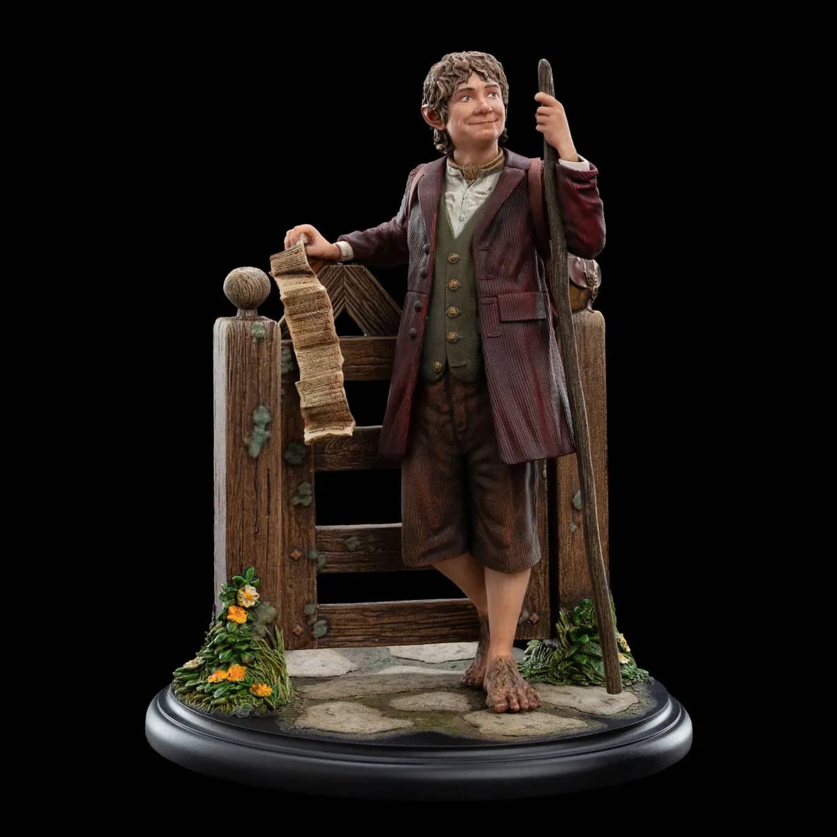 Mini statue de Bilbo Bessac appuyé au portail de Cul-de-Sac, contrat à la main