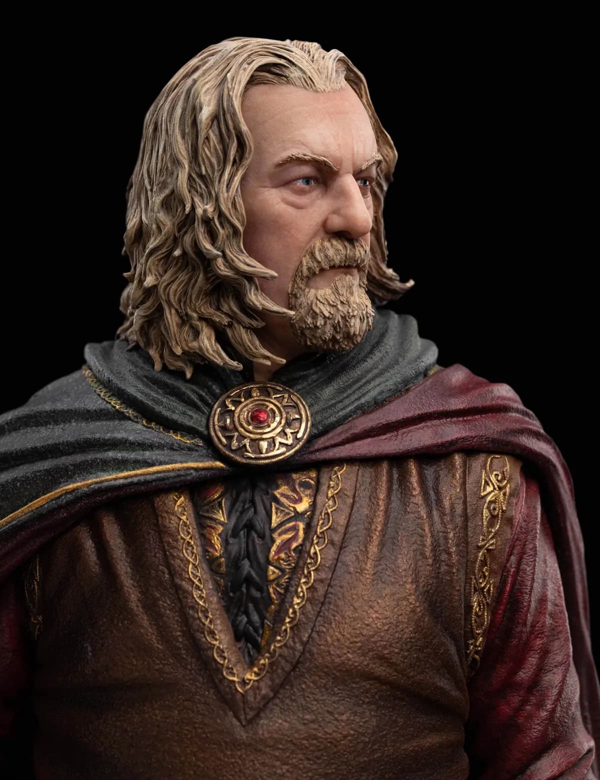 Gros plan sur le visage de la statue de Théoden et sa broche du Rohan