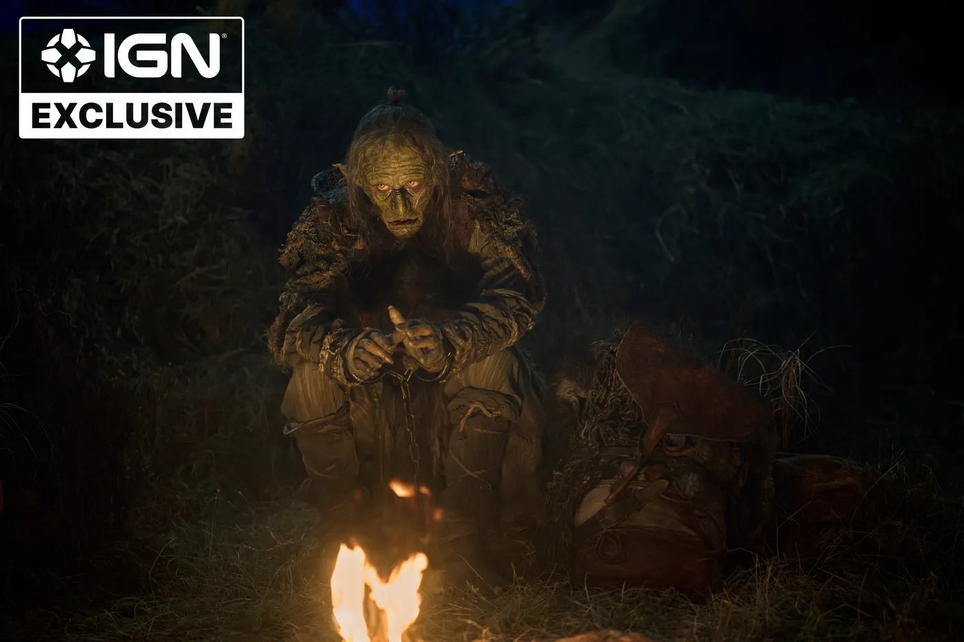 Marnûkh accroupi près d'un feu de camp, de nuit