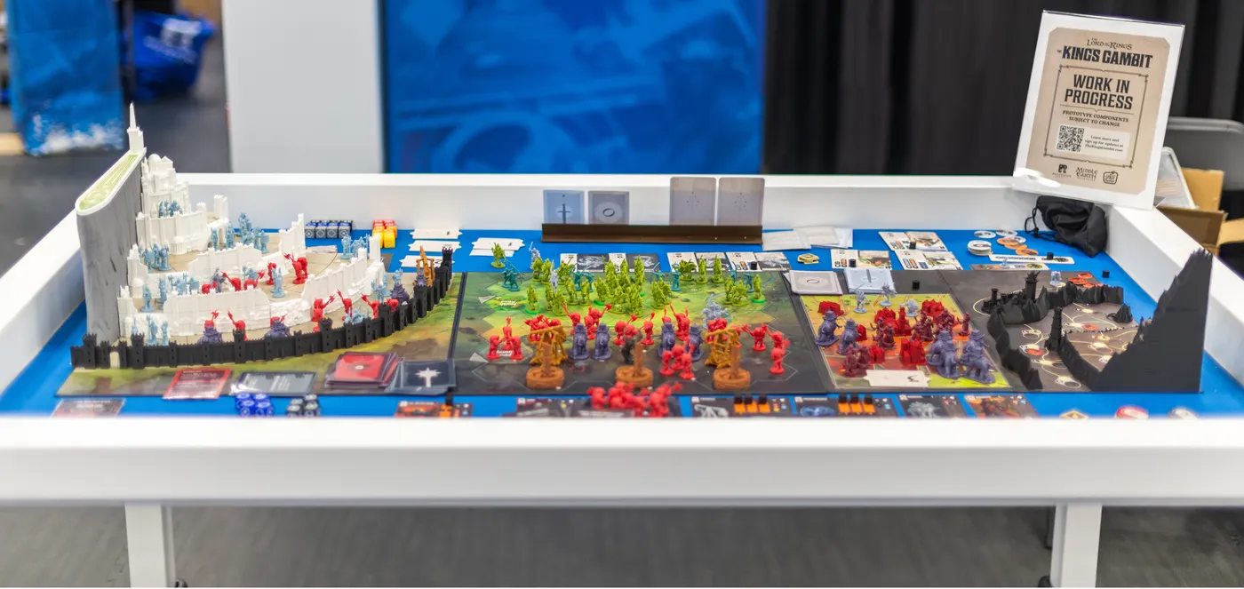 Une partie complète de The King's Gambit installée sur une table de salon, avec Minas Tirith à gauche, le Pelennor au centre et le Mordor à droite