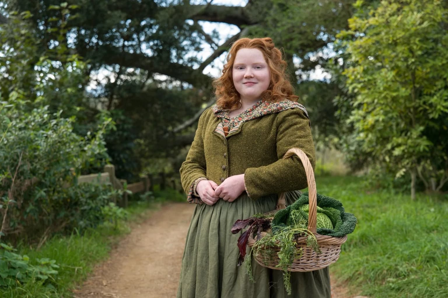 Une jeune Hobbit tient un panier rempli de légumes fraîchement récoltés