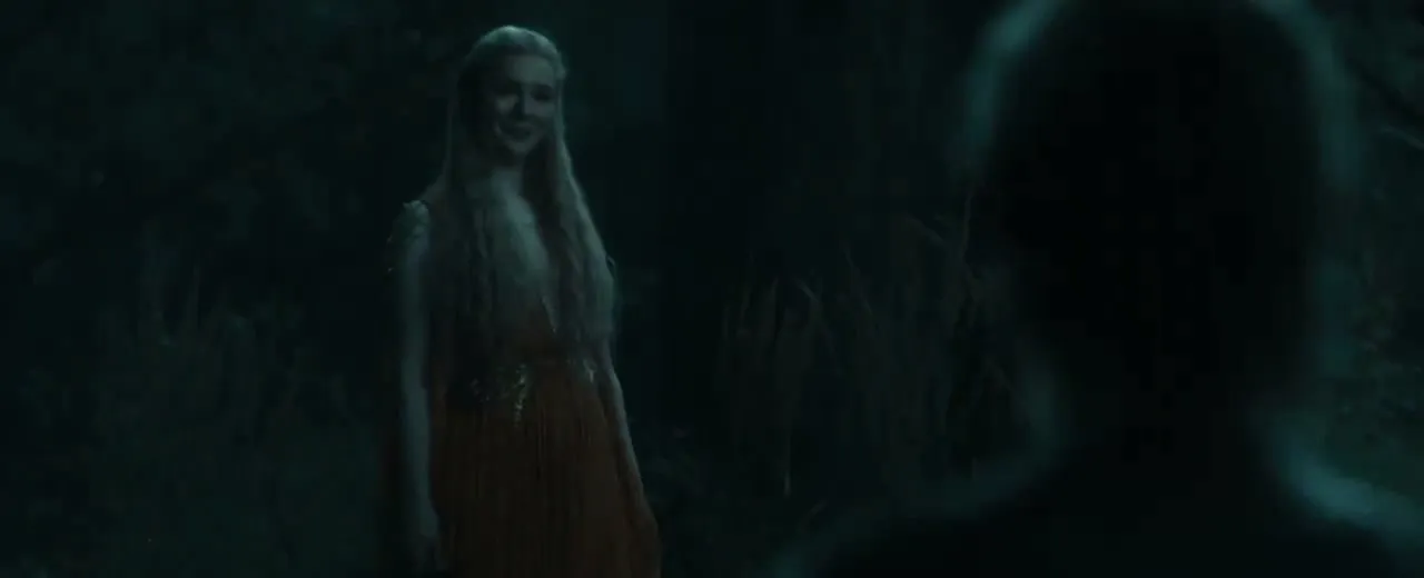 Galadriel, jouée par Morfydd Clark, sourit dans la forêt